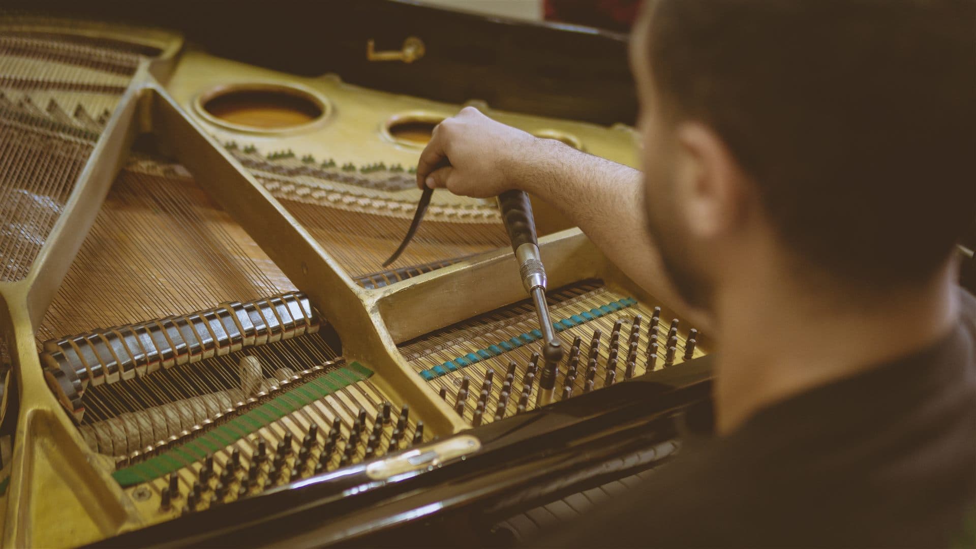 Technician working on grand piano